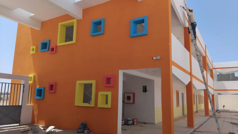 Photo de chantier d’un bâtiment aux façades orange et blanche